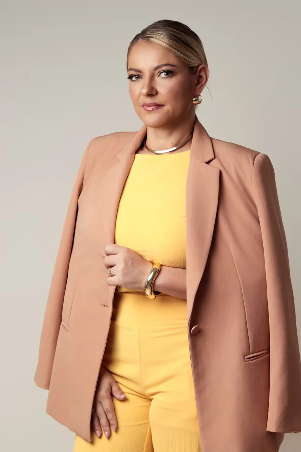 Dra. Núbia Kênia em retrato profissional com blazer rosé
